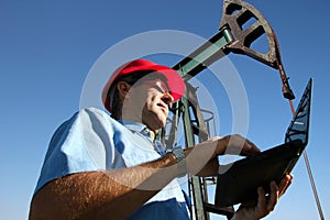 Petroleum Engineer Using Laptop in an Oil Field