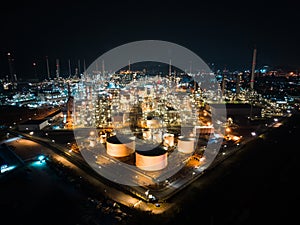 Petroleum oil refinery in industrial estate at night, drone aerial view. Fuel and power generation, petrochemical factory industry