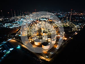 Petroleum oil refinery in industrial estate at night, drone aerial view. Fuel and power generation, petrochemical factory industry