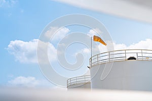 Petroleum oil storage tank with wind socks with blue sky. Industrial petroleum plant. Base oil for automotive engine oil and