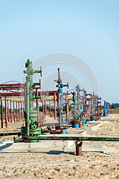 Petroleum well wellhead equipment. Hand valve with handwheel on the flow line. Oilfield site. Oil, gas industry concept