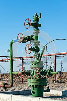 Petroleum well wellhead equipment. Hand valve with handwheel on the flow line. Oilfield site. Oil, gas industry concept