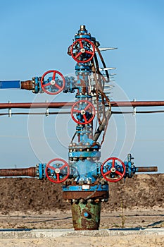 Petroleum well wellhead equipment. Hand valve with handwheel on the flow line. Oilfield site. Oil, gas industry concept