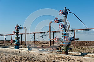 Petroleum well wellhead equipment. Hand valve with handwheel on the flow line. Oilfield site. Oil, gas industry concept