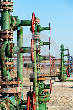 Petroleum well wellhead equipment. Hand valve with handwheel on the flow line. Oilfield site. Oil, gas industry concept