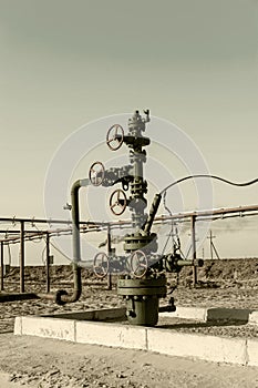 Petroleum well wellhead equipment. Hand valve with handwheel on the flow line. Oilfield site. Oil, gas industry concept