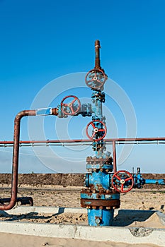 Petroleum well wellhead equipment. Hand valve with handwheel on the flow line. Oilfield site. Oil, gas industry concept