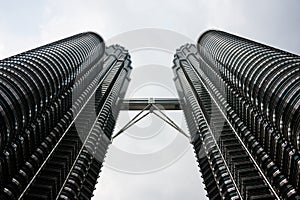 Petronas Towers from the ground leaning into the sky. Towering overhead.