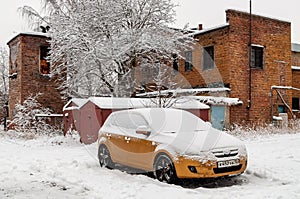 Yellow car under snow after heavy snowfall