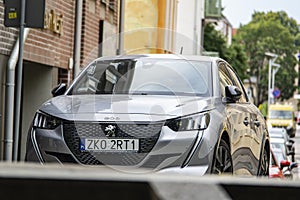 Peugeot 208 silver hatchback car on a streets of Koszalin in Poland