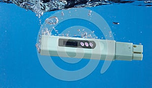 PH acid level test Device tools on quality water on screen. PH acid level tester device tools fall under water splashing photo