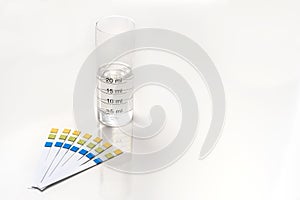 Ph test strips with a test tube graduated with wather