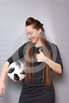 Ph6. A beautiful young lady with long hair in an elegant dress. Posing with a soccer ball.