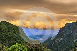 Pha hee mountain with orange rainy cloud in background , Chiang Rai ,Thailand photo