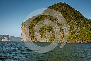 Phangnga Bay ocean with green Island on a beautiful day with blue sky, longtail boat sail on ocean in Thailand