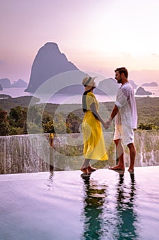 Phangnga Bay Thailand, couple on the edge of an swimming pool watching sunrise Thailand infinity pool