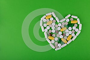 Pharmaceutical concept. Top view on variety of different pills, capsules on green background. Flat lay, copy space for text