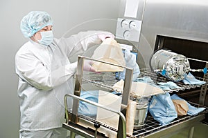 Pharmaceutical factory. worker operating autoclave for medicine sterilization