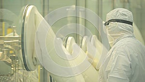 Pharmaceutical industry. Male factory worker inspecting quality of pills packaging in pharmaceutical factory. Automatic