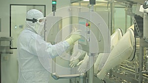 Pharmaceutical industry. Male factory worker inspecting quality of pills packaging in pharmaceutical factory. Automatic