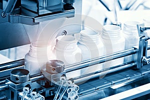 Pharmaceutical industry, medicine pills are filling in the  bottle on production line machine conveyor at the medical factory. sel