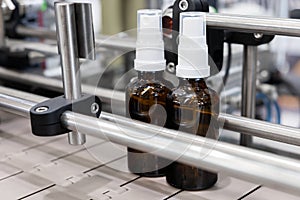 Pharmaceutical industry, medicine pills are filling in the  glass bottle on production line machine conveyor at the medical