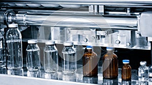 Pharmaceutical industry, medicine pills are filling in the  glass bottle on production line machine conveyor at the medical factor