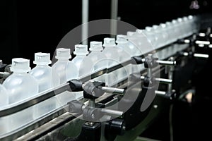 Pharmaceutical industry, medicine pills are filling in the plastic bottle on production line machine conveyor at the