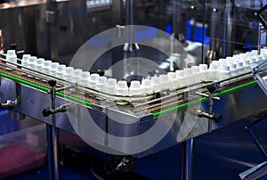 Pharmaceutical industry. Production line machine conveyor at factory with bottles