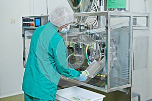 Pharmaceutical industry. technician works with medicine packing machine photo