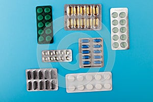 Pharmaceutical medication and medicine pills in packs on blue table