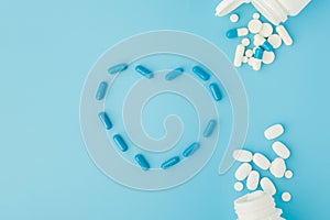 Pharmaceutical medicine pills, tablets and capsules in the shape of a heart on a blue background