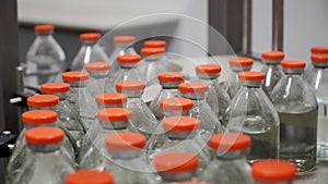 Pharmaceutical production line. Industry medical medicines. Packing pallets with bottles filled with liquid and with red