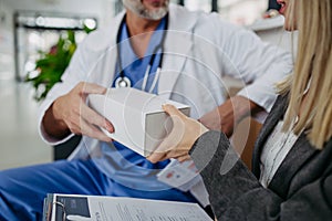 Pharmaceutical sales representative presenting new medication to doctor in medical building.