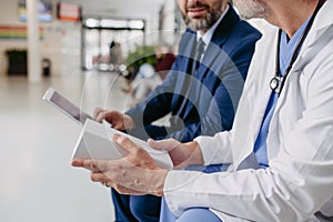 Pharmaceutical sales representative presenting new medication to doctor in medical building.