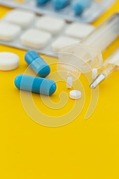 Pharmaceuticals antibiotics capsule pill medicine yellow background with copy space
