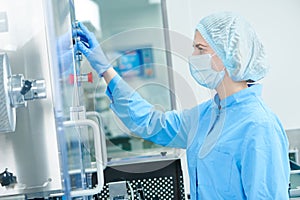 Pharmaceutics. Pharmaceutical worker operates blister packaging machine photo