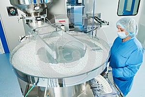 Pharmaceutics. Pharmaceutical worker operates tablet blister packaging machine photo