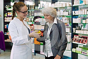 Pharmacist advising medication to senior patient.