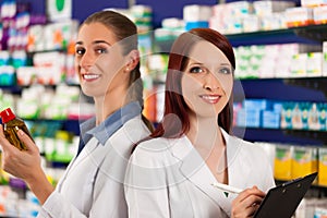 Pharmacist with assistant in pharmacy