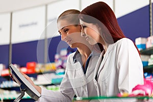 Pharmacist with assistant in pharmacy