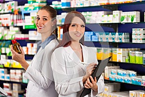 Pharmacist with assistant in pharmacy
