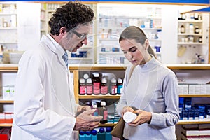 Pharmacist assisting the bottle of drug to customer