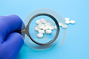 Pharmacist or expert on pharmaceutical inspection identifies pills. Testing, verification and determining pharmaceutical counterfe