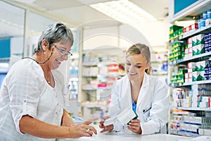 Pharmacist explaining prescription medication to woman in the pharmacy for pharmaceutical healthcare treatment. Medical