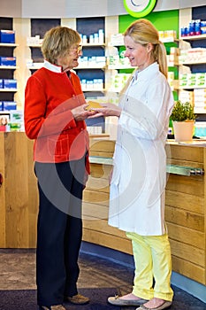 Pharmacist giving customer medication order
