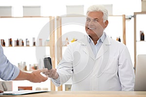 Pharmacist giving medicine to customer