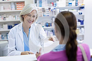 Pharmacist giving prescriptions of medicine to customer photo