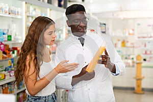 Pharmacist giving woman guidance about haircare