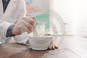 Pharmacist grinding a preparation using a pestle